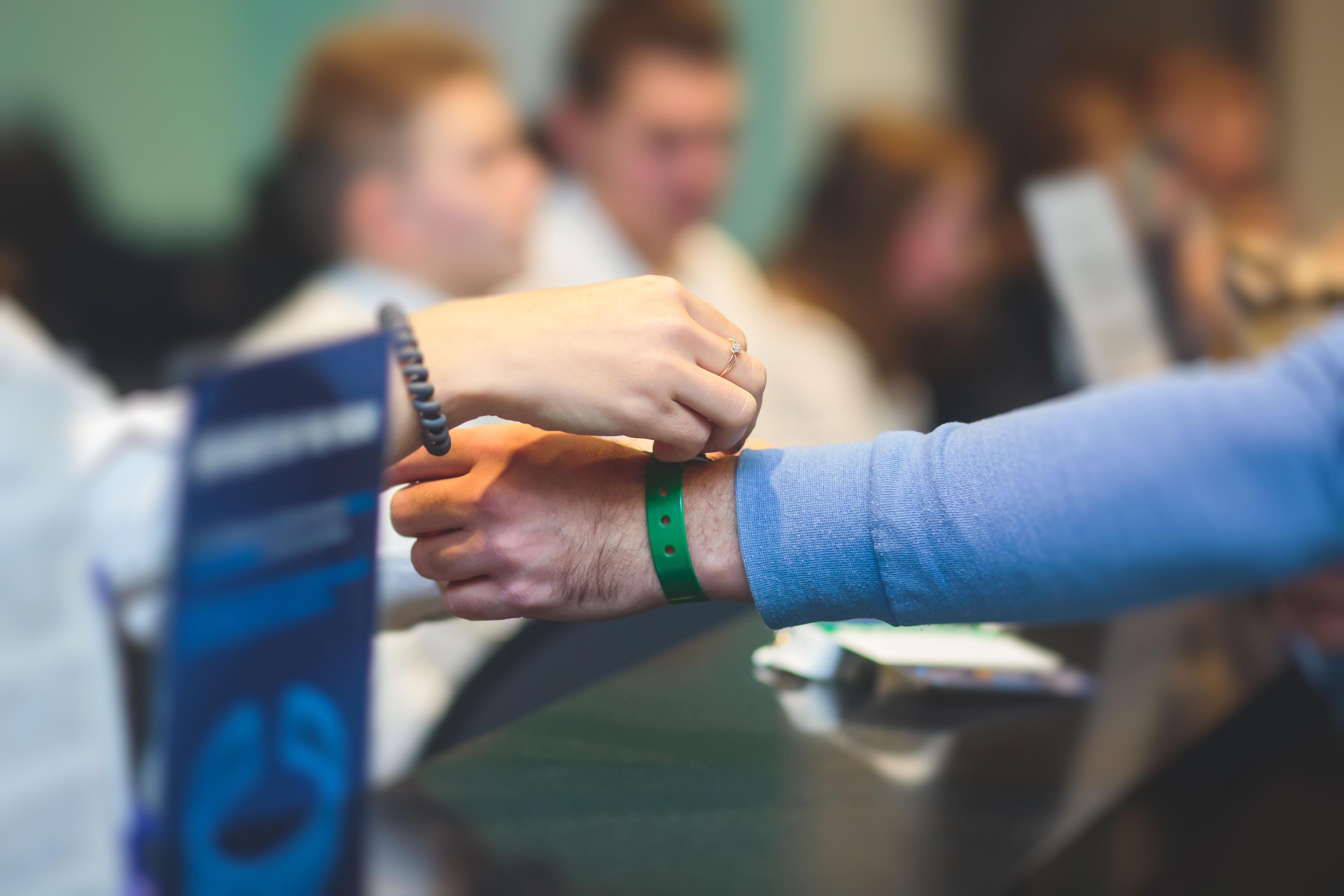 registrering vid ett event, en person fäster ett armband på en annan person