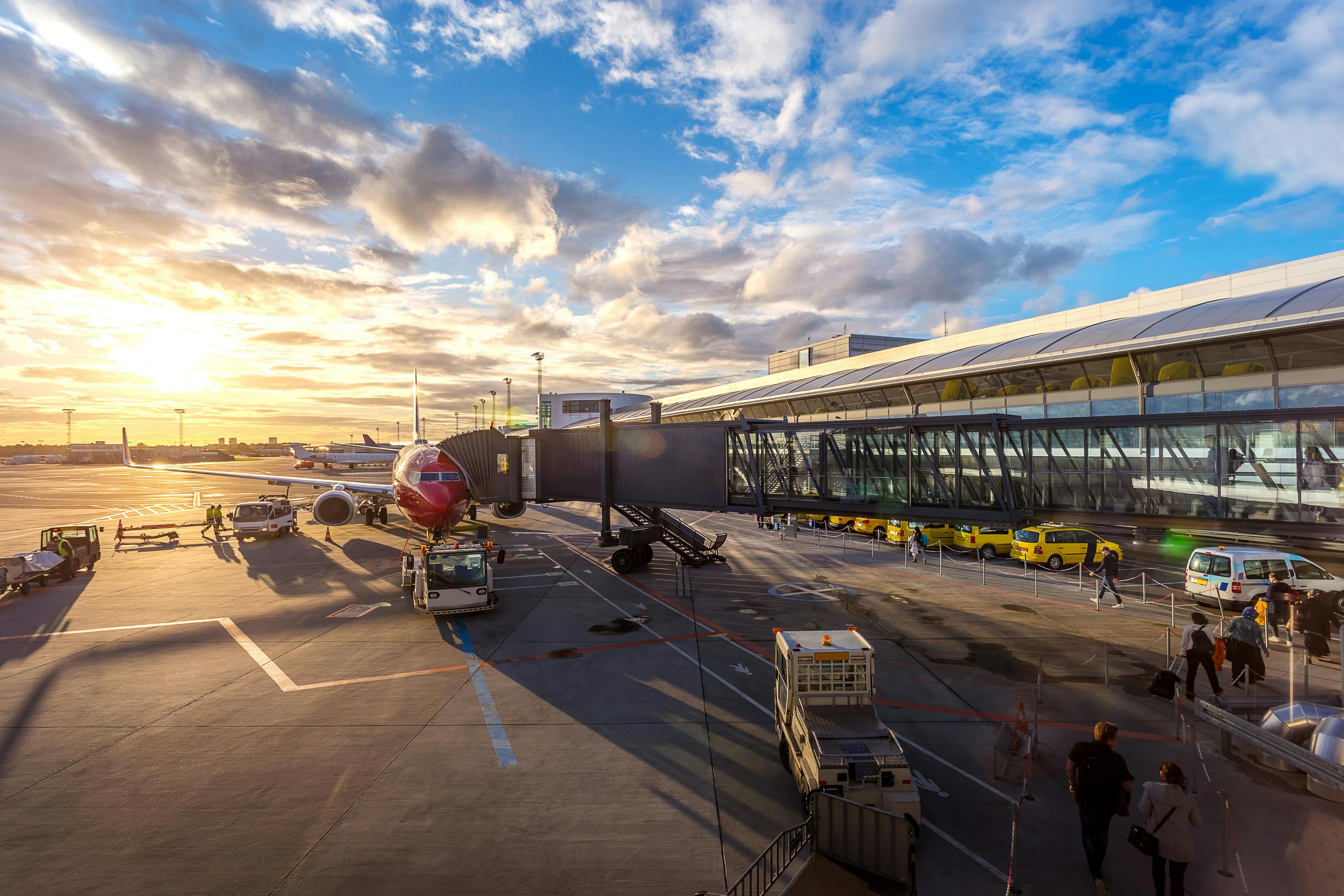 Flygplan som står parkerat vid en boardingbrygga på Kastrup flygplats, redo för ombordstigning.